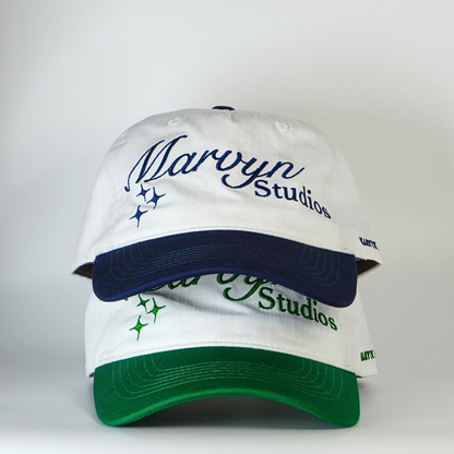 White cap with blue and green accents featuring 'Marvyn Studios' branding on a white background