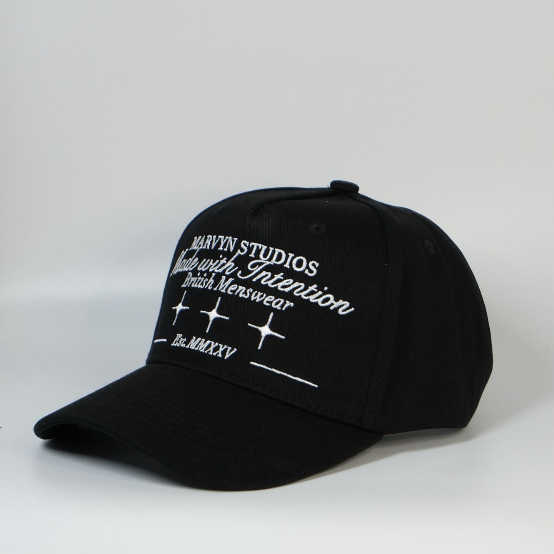 Black cap with white text and branding on a light gray background