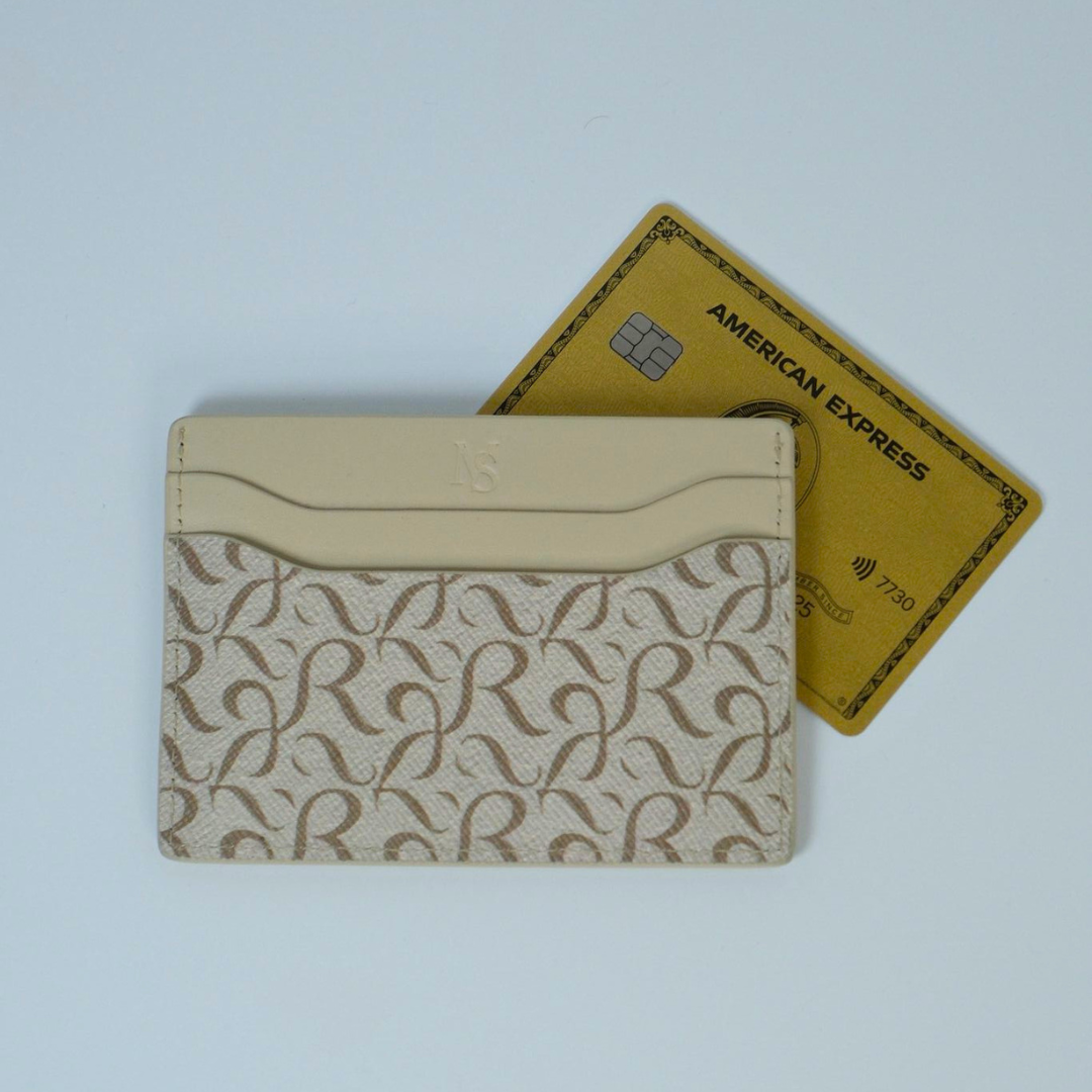 Beige cardholder with pattern and American Express card on a light blue background