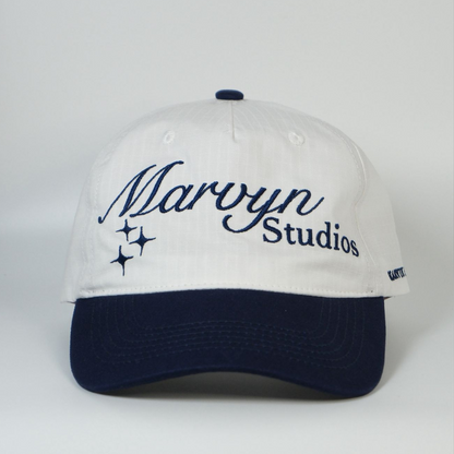 White cap with navy blue brim and embroidered text on a white background